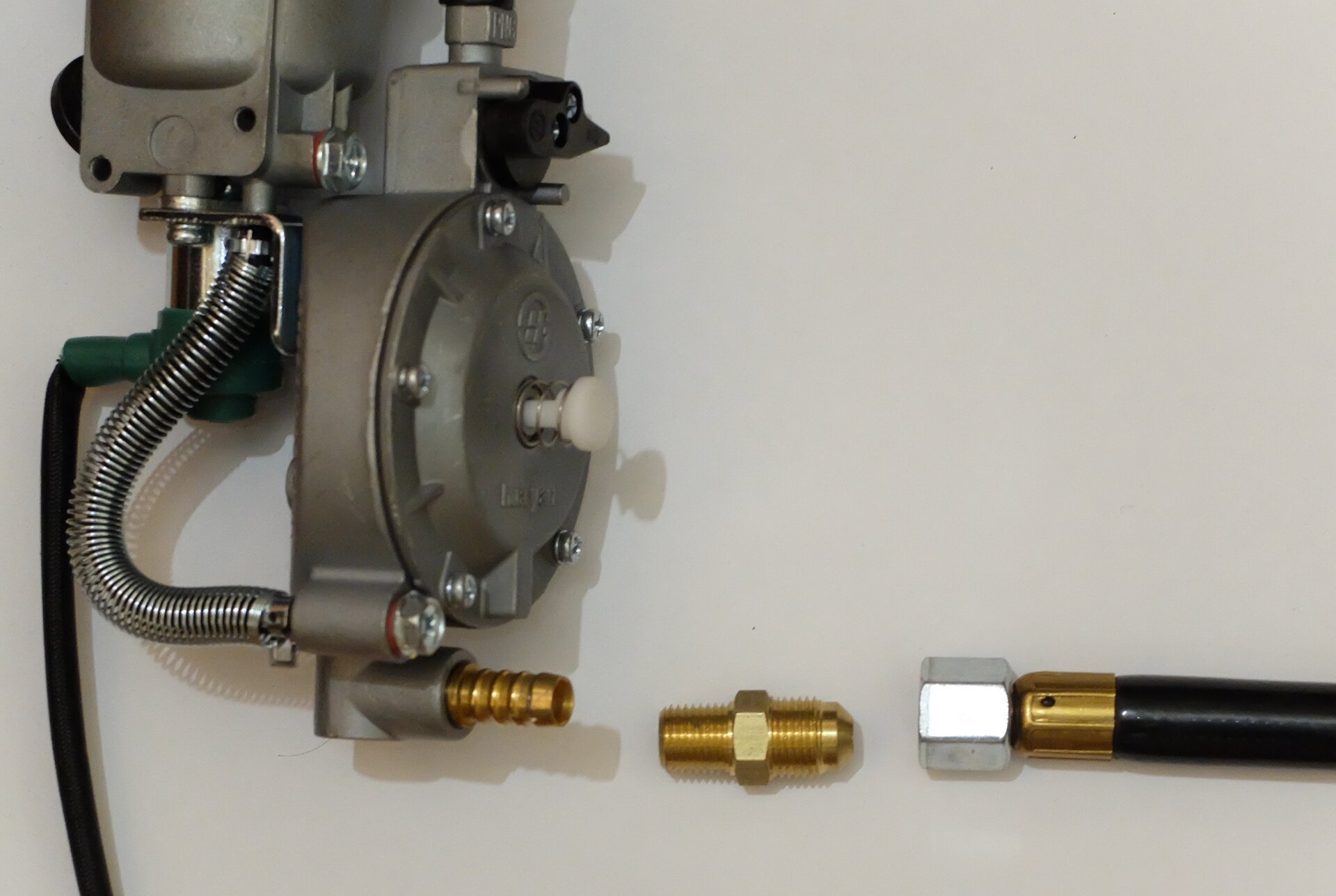 There was a problem, because I needed to connect the new multi-fuel carburetor, at left, to the house on the right. The recommended fitting, center, didn't work. (Credit: Dennis E. Powell)