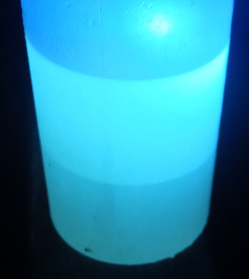 An ultraviolet light makes it a little easier to see which is the water -- the layer at bottom -- and the gasoline above it. (Credit: Dennis E. Powell)